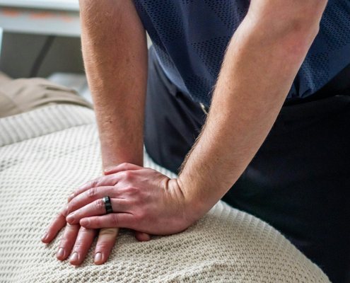 Chiropraticien effectuant un ajustement vert&eacute;bral sur le dos d'un patient