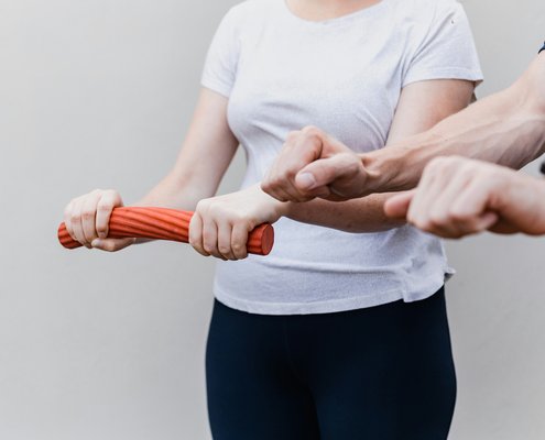 Physioth&eacute;rapeute guidant une patiente lors d'un exercice de renforcement du poignet